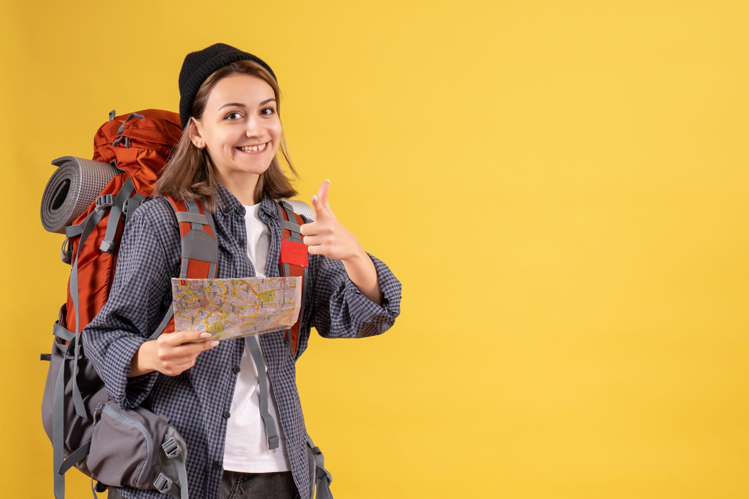 smiling young traveller with backpack holding map pointing camera scaled 1